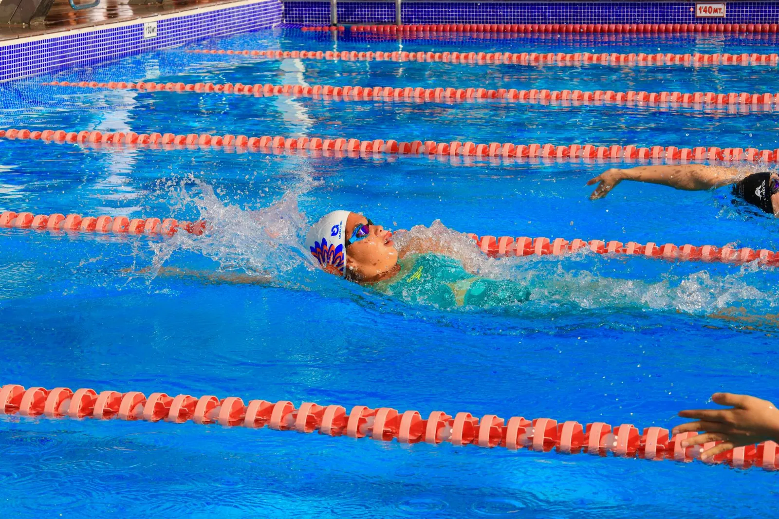 Nadadora del club nadando espalda en competición