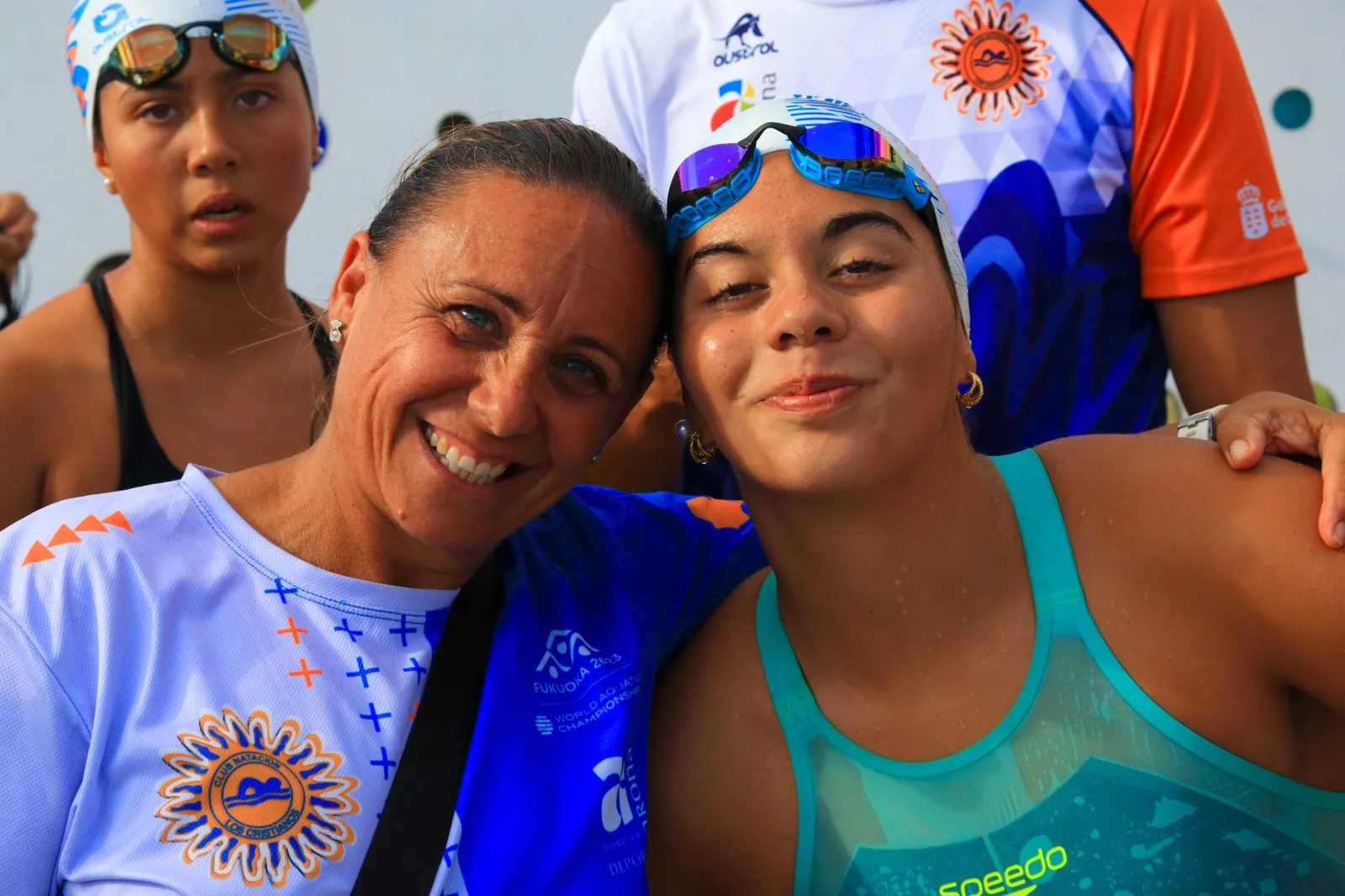 María Asencio abrazada a una nadadora del club tras una prueba