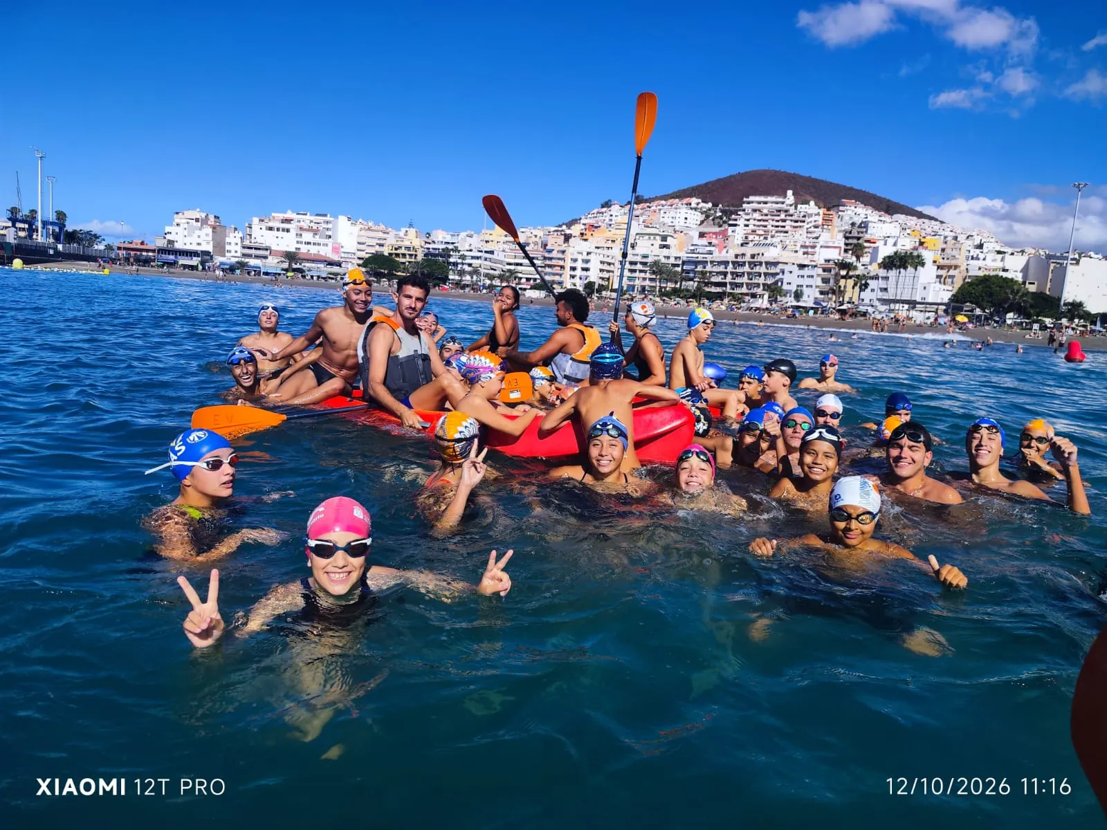 Nadadores del club en el mar con kayaks de la Escuela de Vela