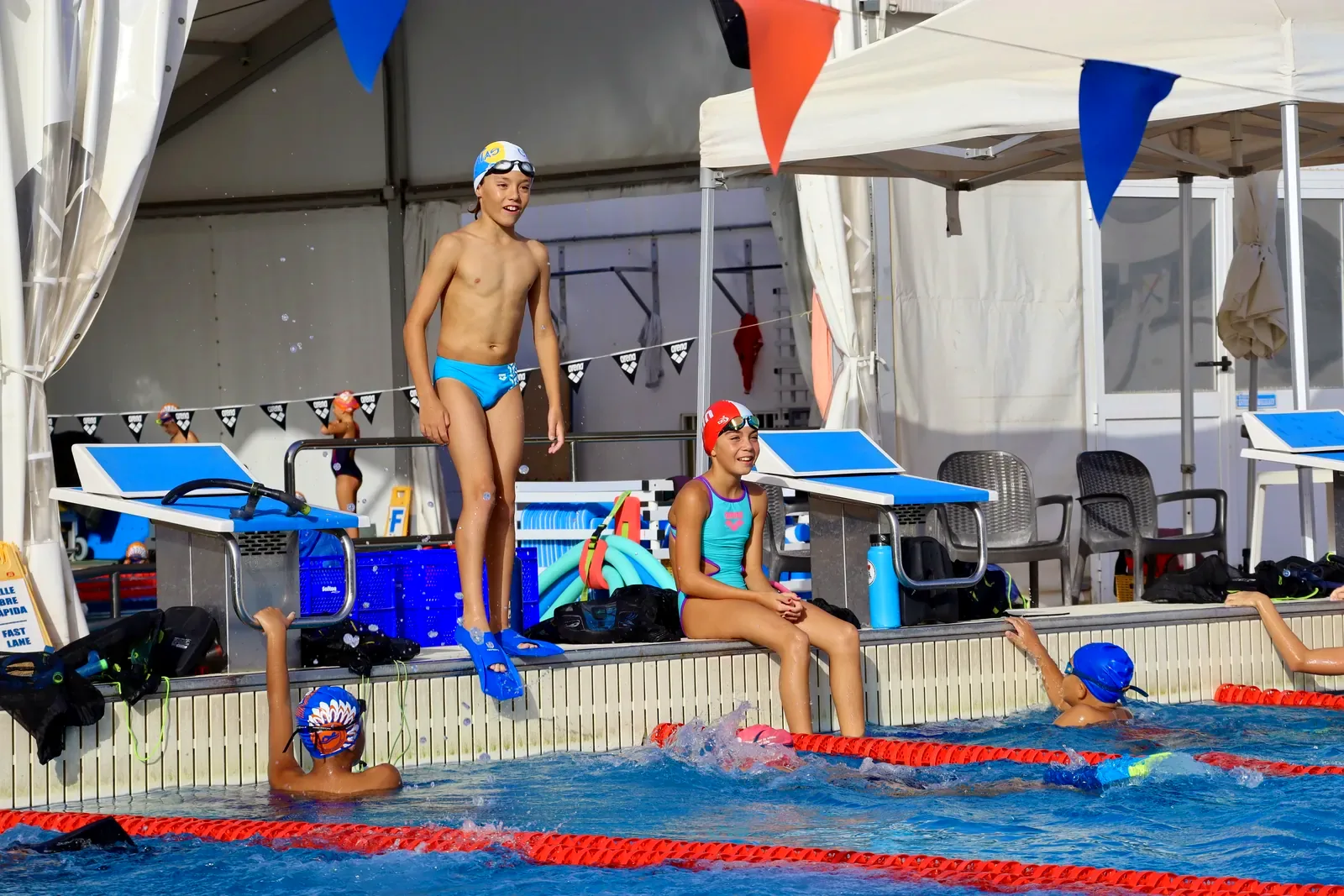 Nadadores benjamines y alevines sonriendo junto a los poyetes