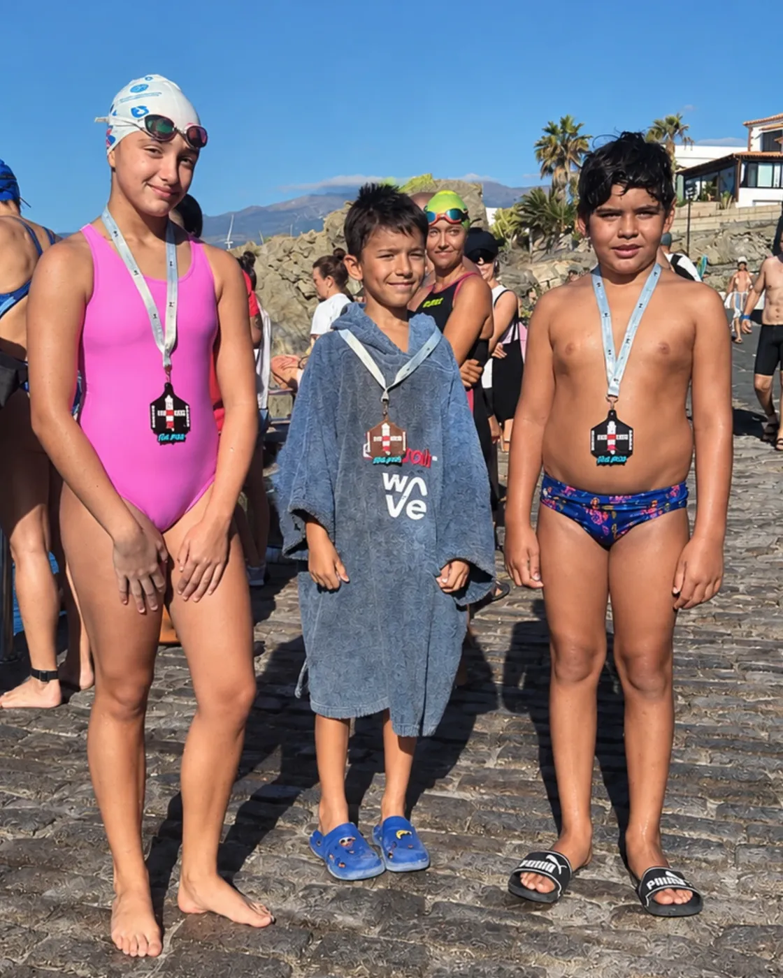 Tres nadadores del club con sus medallas de la Blue Arico