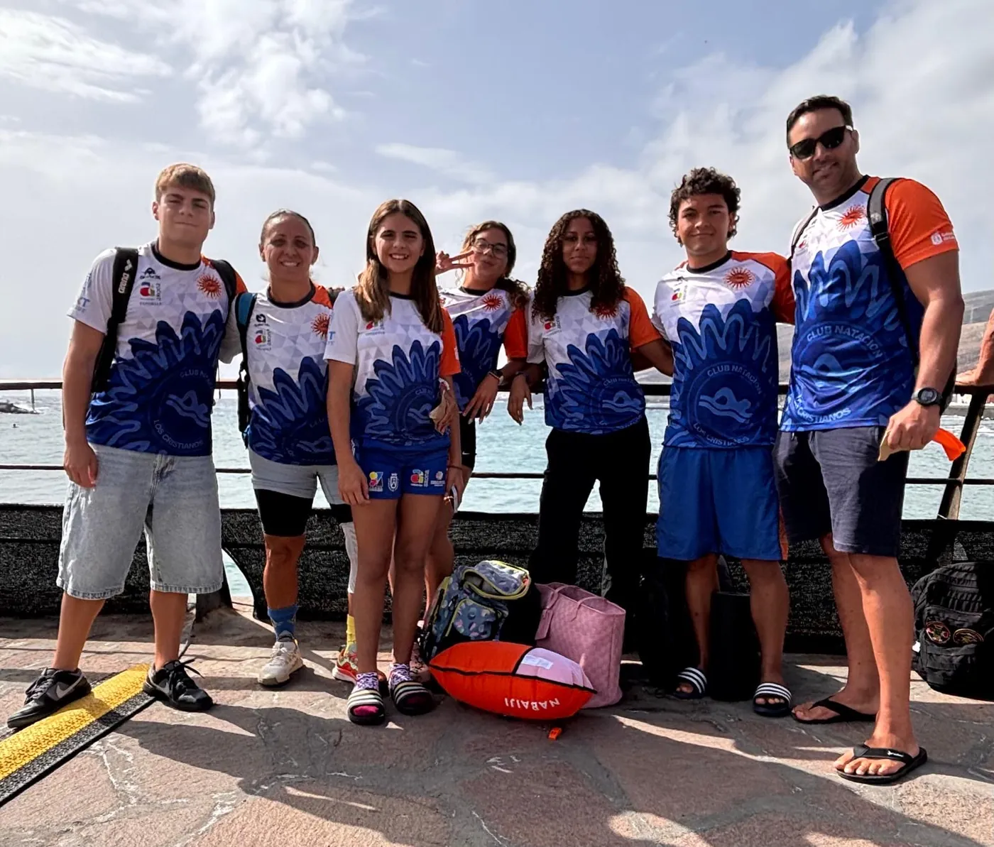 Nadadores y entrenadores del club con la equipación junto al mar en Güímar