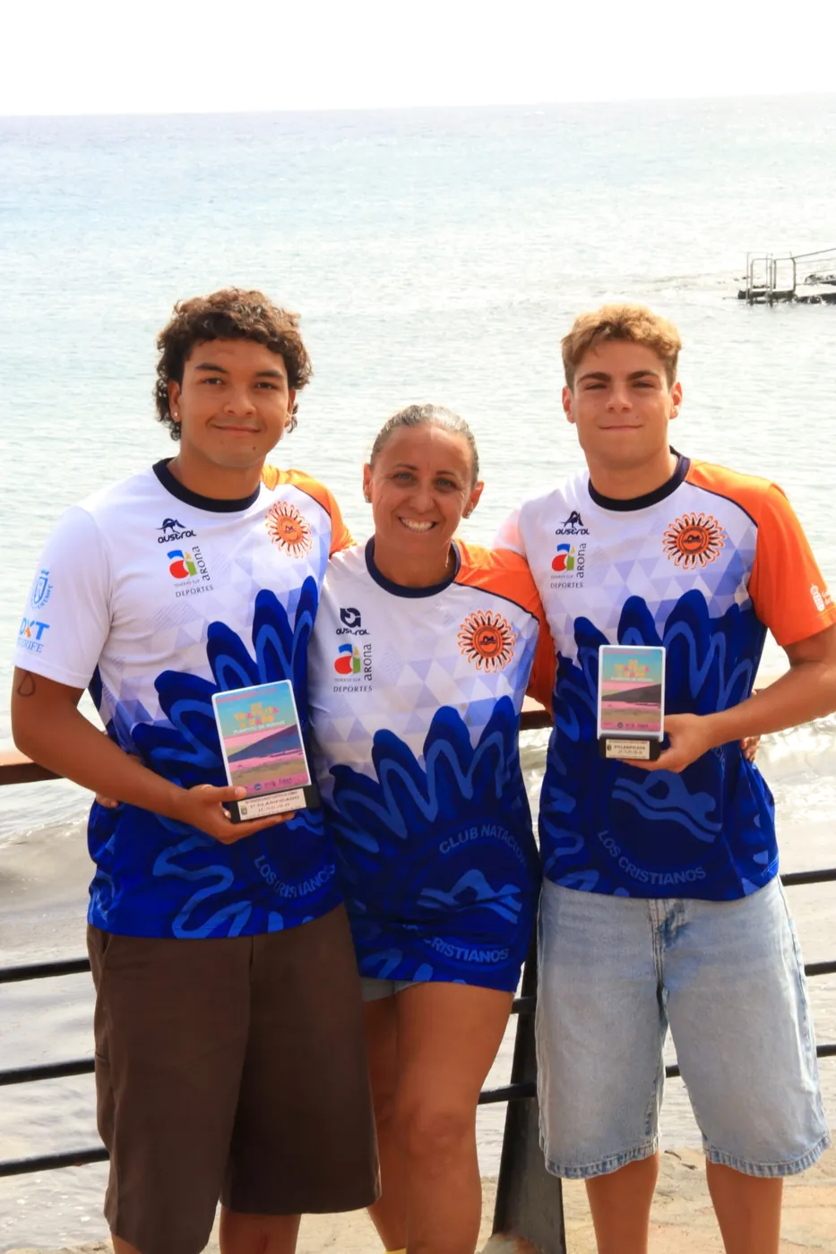 María Asencio con dos nadadores del club que muestran sus trofeos